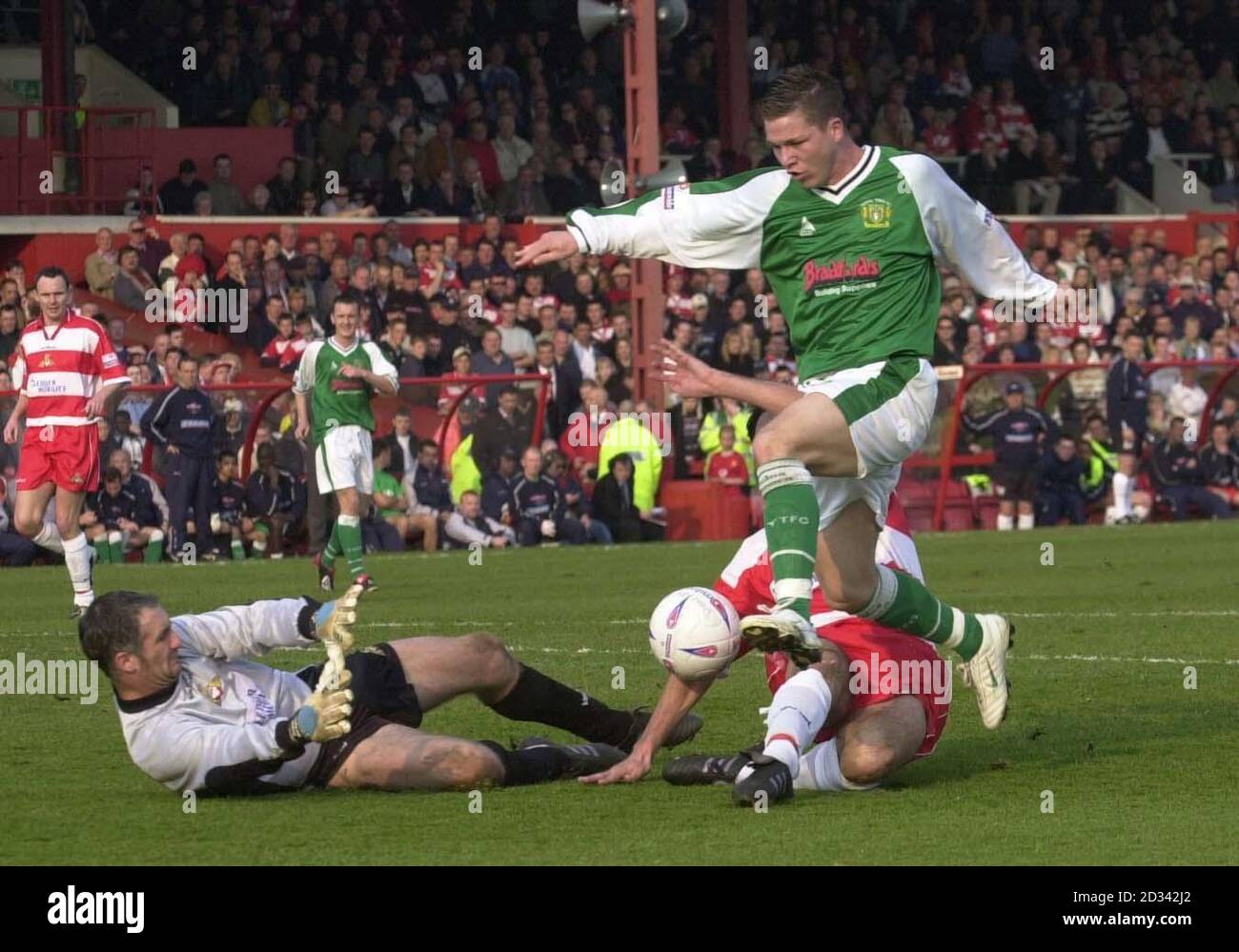 Yeovil Town's Kevin Gall (top) clears the outstretched legs of Doncaster Rovers' Steve Foster as Rovers' 'keeper Andy Warrington (L) slides in the gather the ball during their Nationwide Conference match at Doncaster's Belle Vue ground.  THIS PICTURE CAN ONLY BE USED WITHIN THE CONTEXT OF AN EDITORIAL FEATURE. NO UNOFFICIAL CLUB WEBSITE USE. Stock Photo