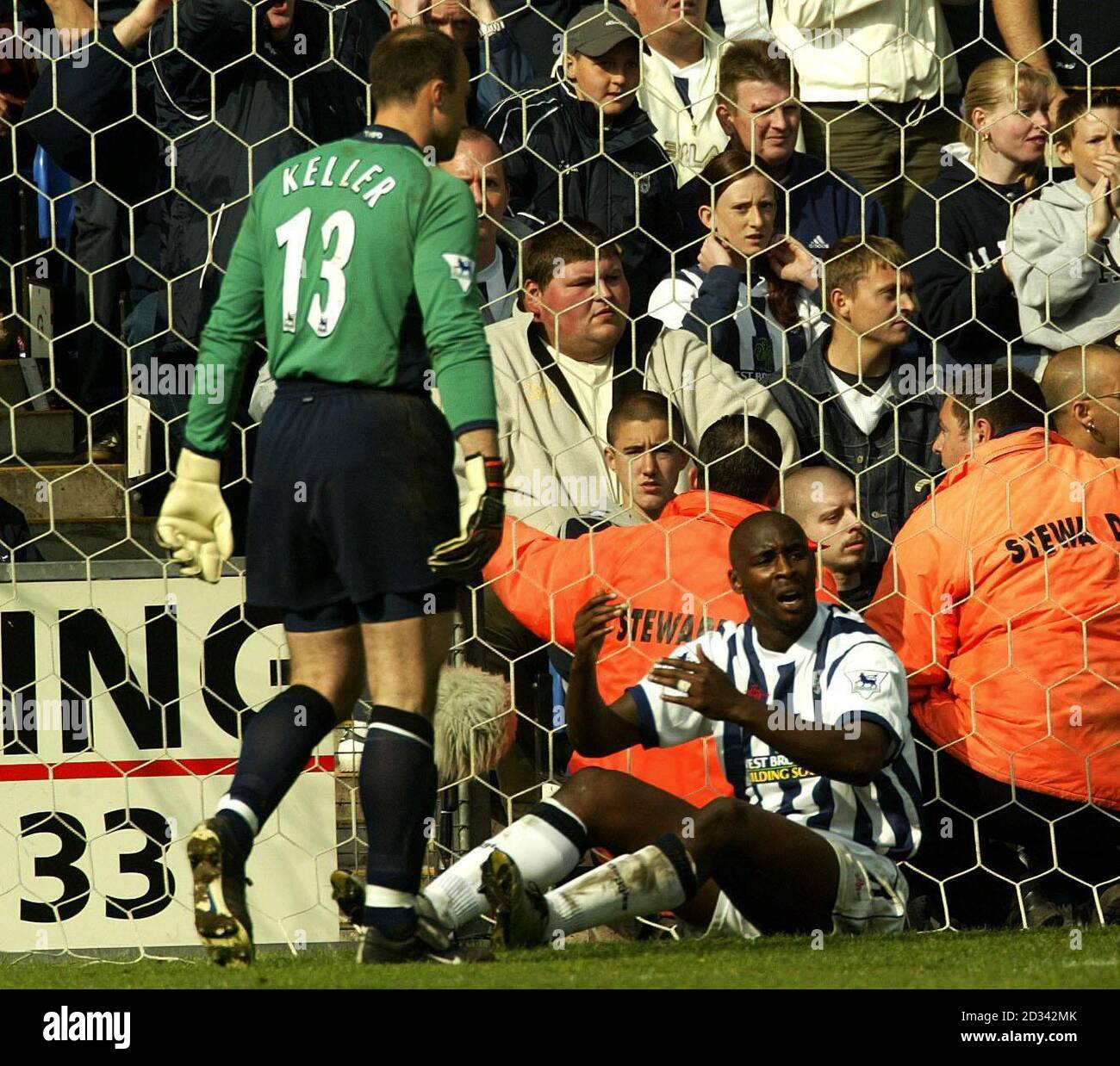 West Bromwich Albion Jason Roberts sits dejected after he put the ball over the bar with Tottenham Hotspur goalkeeper Kasey Keller (left) looking on during the FA Barclaycard Premiership match at The Hawthorns, Birmingham.    THIS PICTURE CAN ONLY BE USED WITHIN THE CONTEXT OF AN EDITORIAL FEATURE. NO WEBSITE/INTERNET USE UNLESS SITE IS REGISTERED WITH FOOTBALL ASSOCIATION PREMIER LEAGUE. Stock Photo