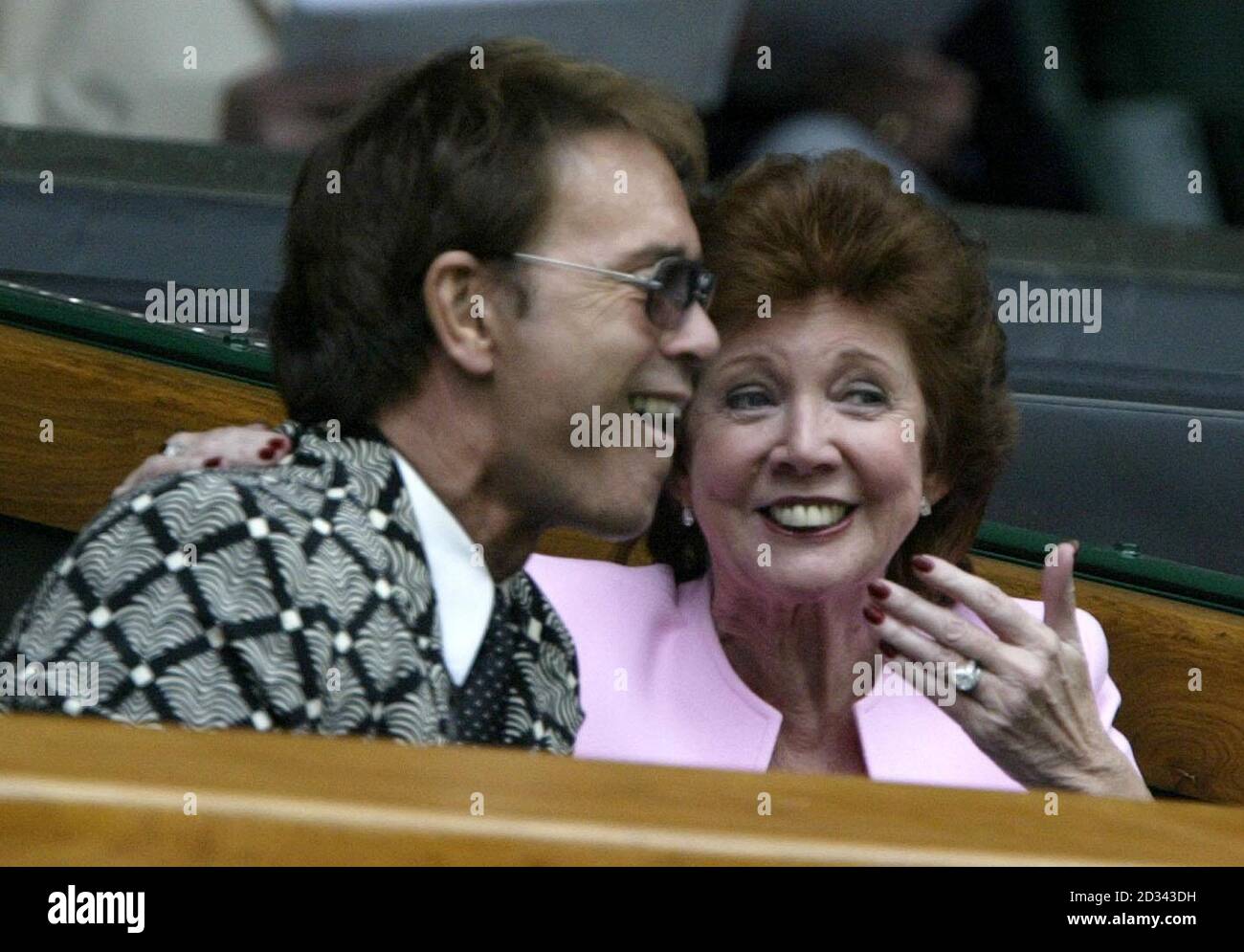EDITORIAL USE ONLY, NO MOBILE PHONE USE. Sir Cliff Richard and Cilla Black share ajoke as they sit in the royal box watching Venus Williams in action against fellow American Lindsay Davenport in the ladies quarter finals at the All England Lawn Tennis Championships at Wimbledon. Stock Photo