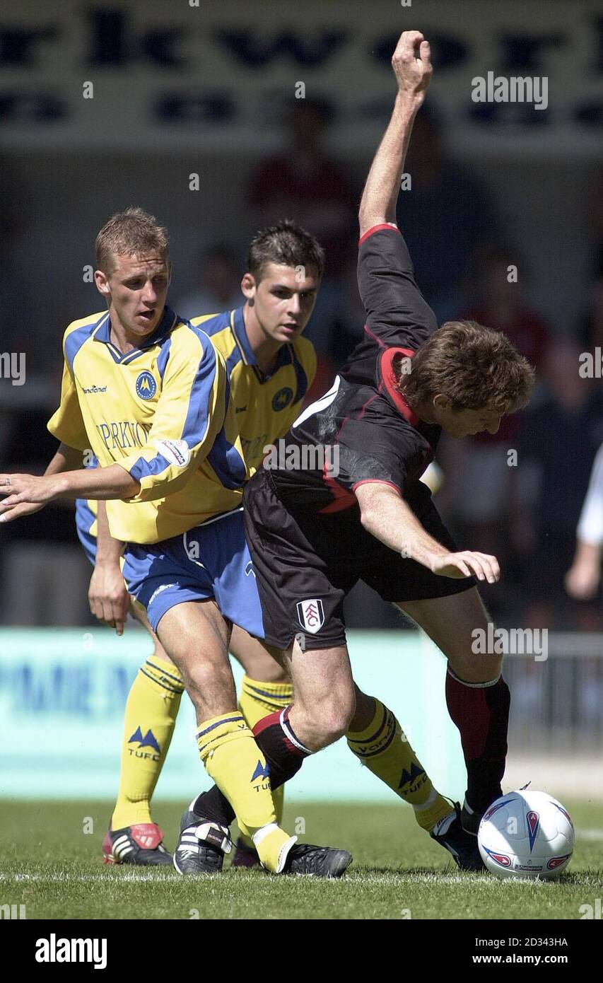 Fulham's Facundo Sava is tackled by Torquay's defenders Craig Taylor (L) and David Woozley (centre) during their pre-season friendly at Torquay's Plainmoor ground. Stock Photo