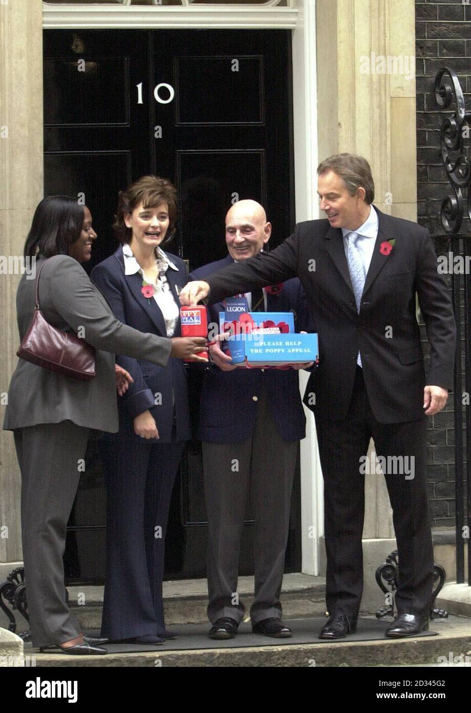 British Prime Minister Tony Blair (right) buys a Remembrance Poppy in Downing Street from Andrea Newsome of the Officers' Association as his wife Cherie and veteran Brian Coombs watch. Stock Photo