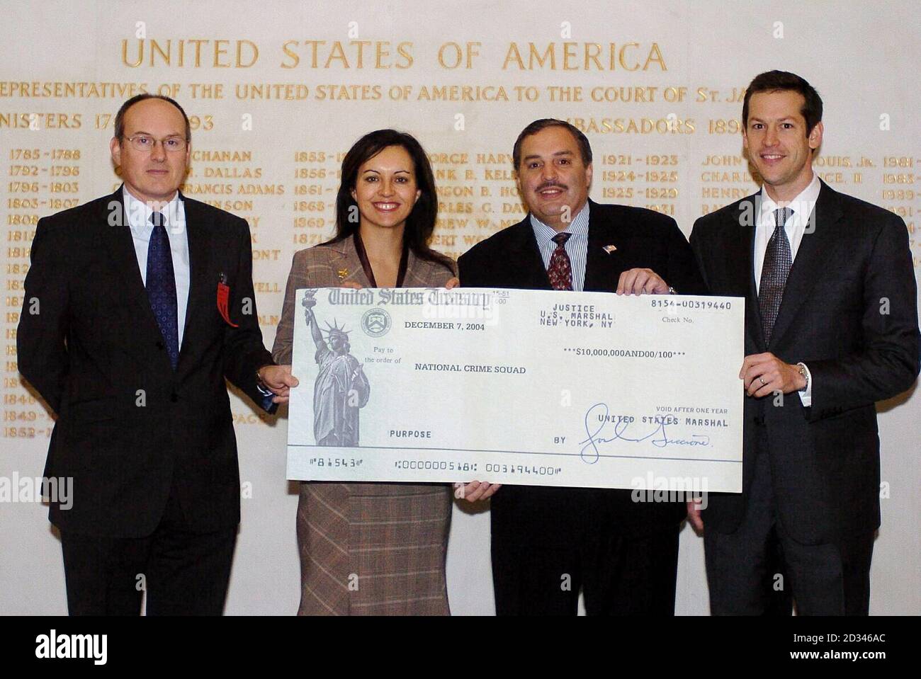 Home Office Minister Caroline Flint receiving a cheque for 5.7 million at the US Embassy in London from Tony Placido, special agent in charge of the US Drug Enforcement Administration in New York with Trevor Pearce (left) from the National Crime and Boyd Johnson (right) from the US Drug Enforcement Administration. The money is half of a $20 million dollar haul resulting from a joint US/UK confiscation order against a Colombian drug trafficker and will be used by the National Crime Squad to tackle crime in the UK. Stock Photo