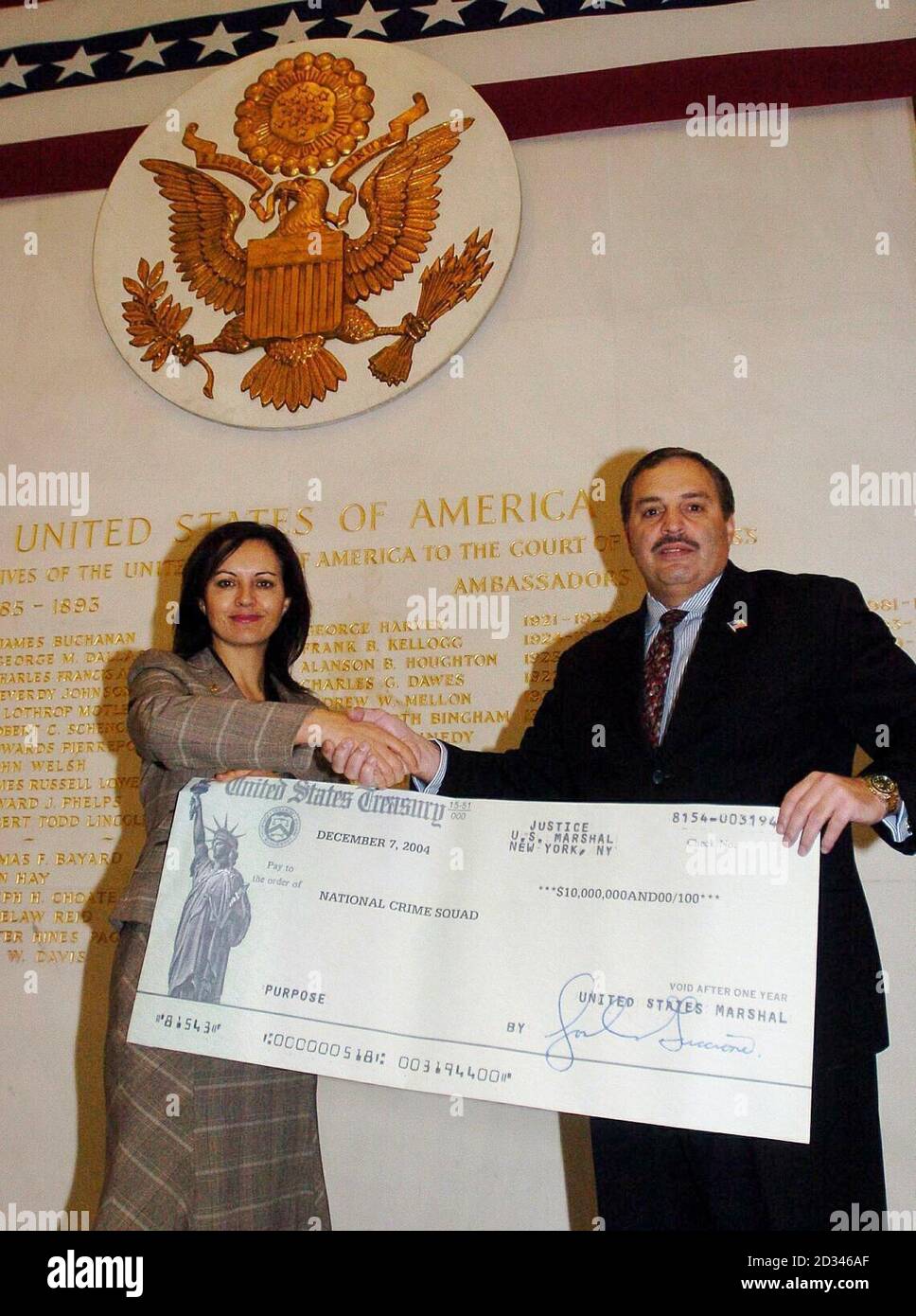 Home Office Minister Caroline Flint receiving a cheque for  5.7 million at the US Embassy in London from Tony Placido, special agent in charge of the US Drug Enforcement Administration in New York. The money is half of a $20 million dollar haul resulting from a joint US/UK confiscation order against a Colombian drug trafficker and will be used by the National Crime Squad to tackle crime in the UK. Stock Photo