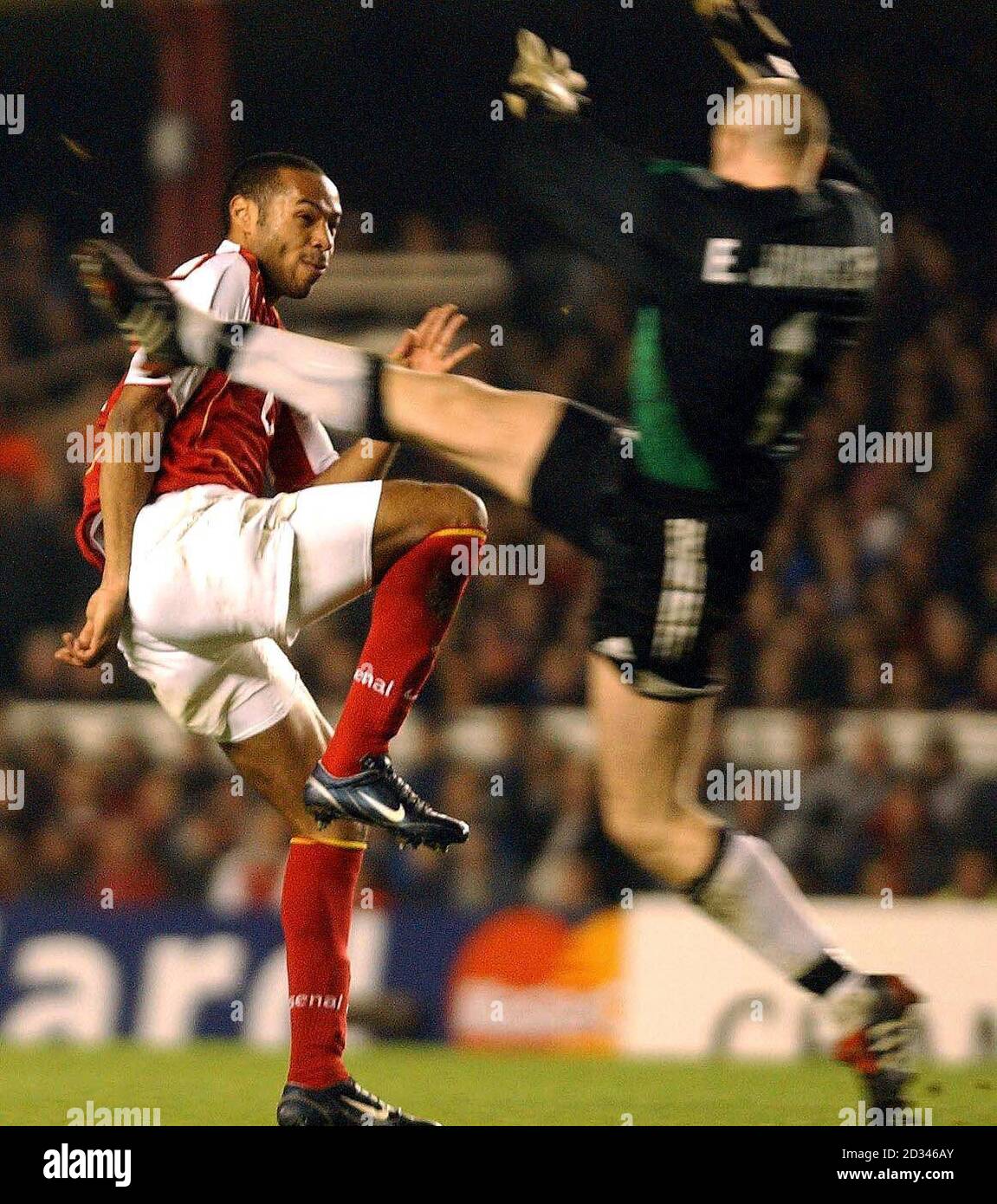 Arsenal striker Thierry Henry lobs the ball to score the second goal past Rosenborg goalkeeper Espen Johnsen (right) during the UEFA Champions League, Group E match at Highbury Stadium, London. Stock Photo