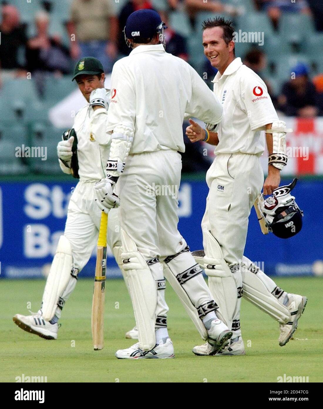 England captain Michael Vaughan (right) smiles as he leaves the field with team-mate Stephen Harmison and South African wicketkeeper Mark Boucher (left) at the end of the the second day. Stock Photo