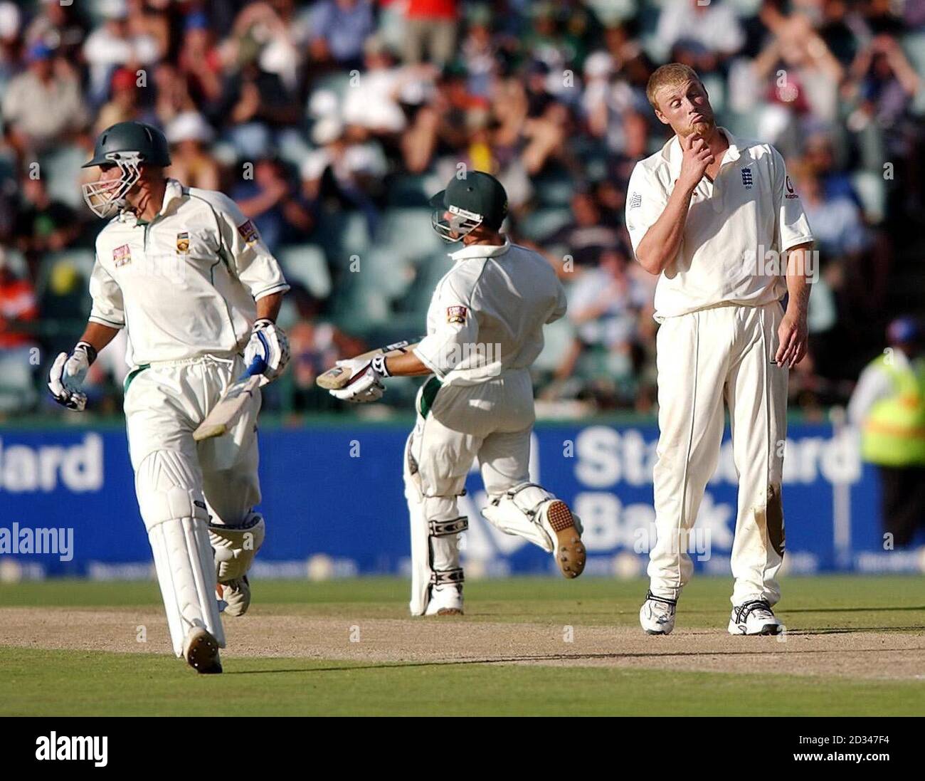 England's Andrew Flintoff (right) reacts as South Africa's herschelle Gibbs (left) and Mark Boucher score runs off his bowling Stock Photo