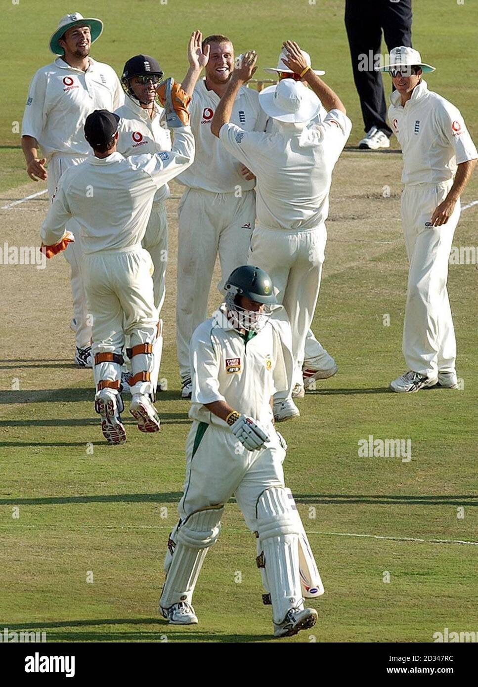 England's Andrew Flintoff (top centre) celebrates with his team mates (facing, from left) Stephen Harmison, Graham Thorpe and captain Michael Vaughan after bowling South Africa's Andrew Hall (bottom) for 9 runs. Stock Photo