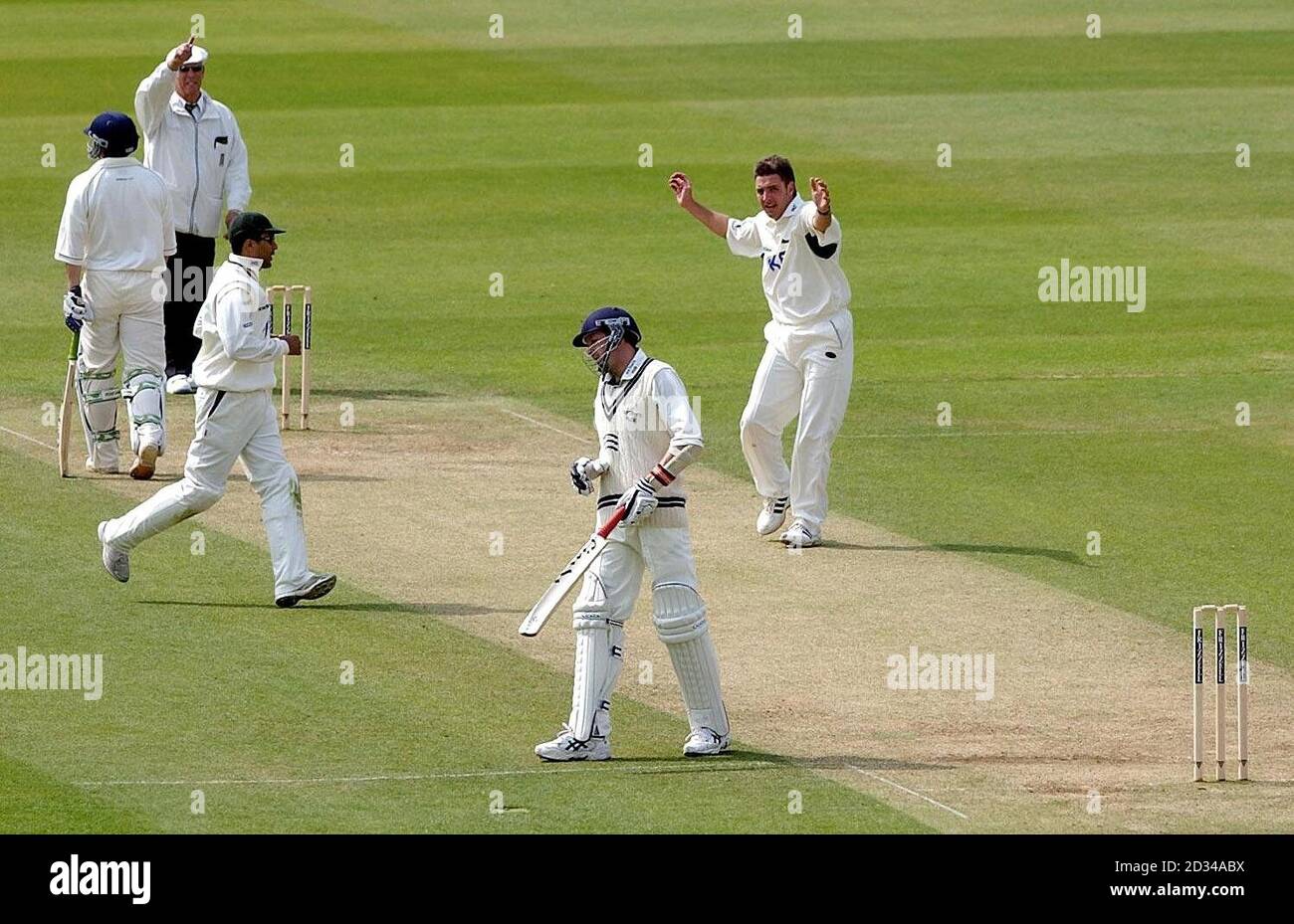 Umpire John Hampshire (top left) raises his finger as Nottinghamshire's Paul Franks (right) celebrates after trapping Middlesex's Alan Richardson (second right) lbw for 15 runs. Stock Photo