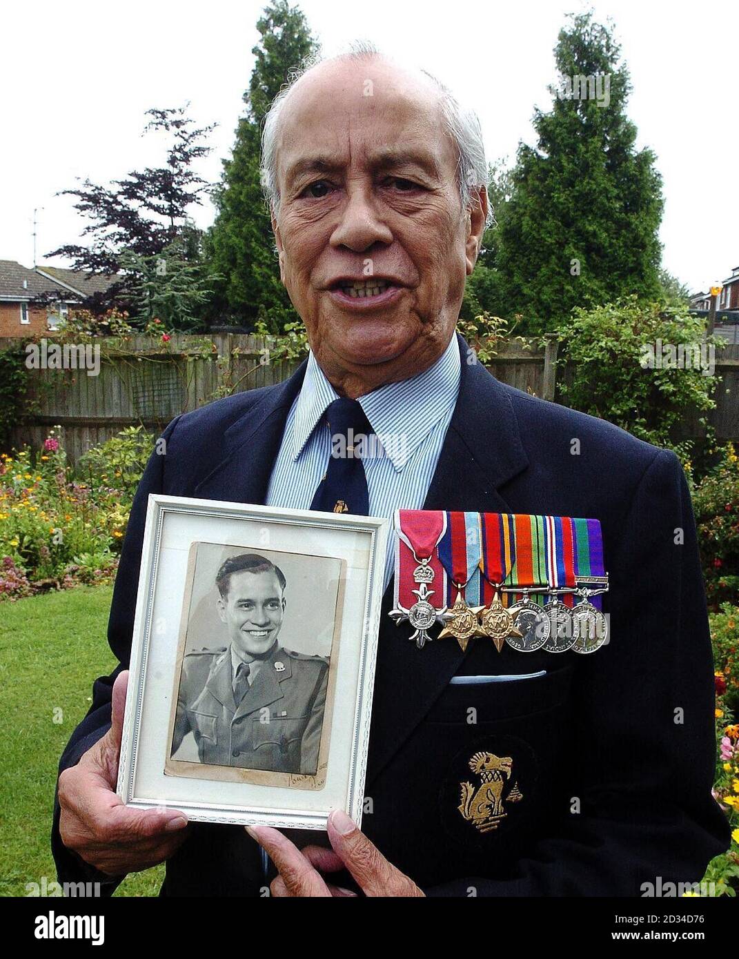 Major Neville Hogan, 84, a former Chindit soldier in Burma holding a photo  of himself as a young soldier, at his home in Hemel Hempstead,  Hertfordshire. Burmese-born Hogan was just 16-years-old when