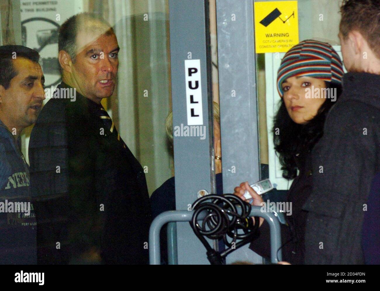 Scottish Socialist Tommy Sheridan and Nationalist stages a pro-asylum protest inside an Immigration Office in Brand Street, Glasgow, Wednesday, November 2, 2005. Pic shows Tommy chatting to director of Positive Action Housing Robina Qureshi through the padlocked doors of the office. Robina said the protest was to highlight the "inhumanities perpetrated" by the Home Office See PA Story SCOTLAND Protest. PRESS ASSOCIATION PHOTO. PHOTO CREDIT SHOULD READ Danny Lawson/PA Stock Photo