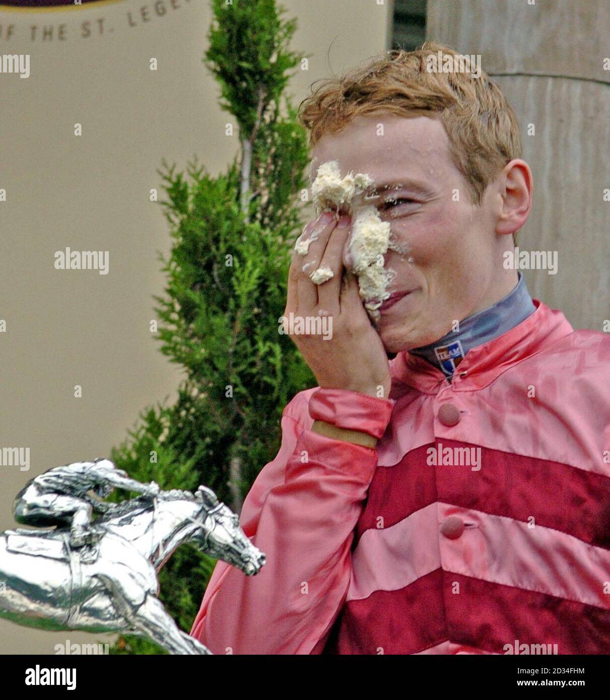 2005's Champion jockey Jamie Spencer wipes cream from his eyes after fellow jockey Tony Culhane surprised him with a cake in his face at Doncaster Saturday November 5, PRESS ASSOCIATION