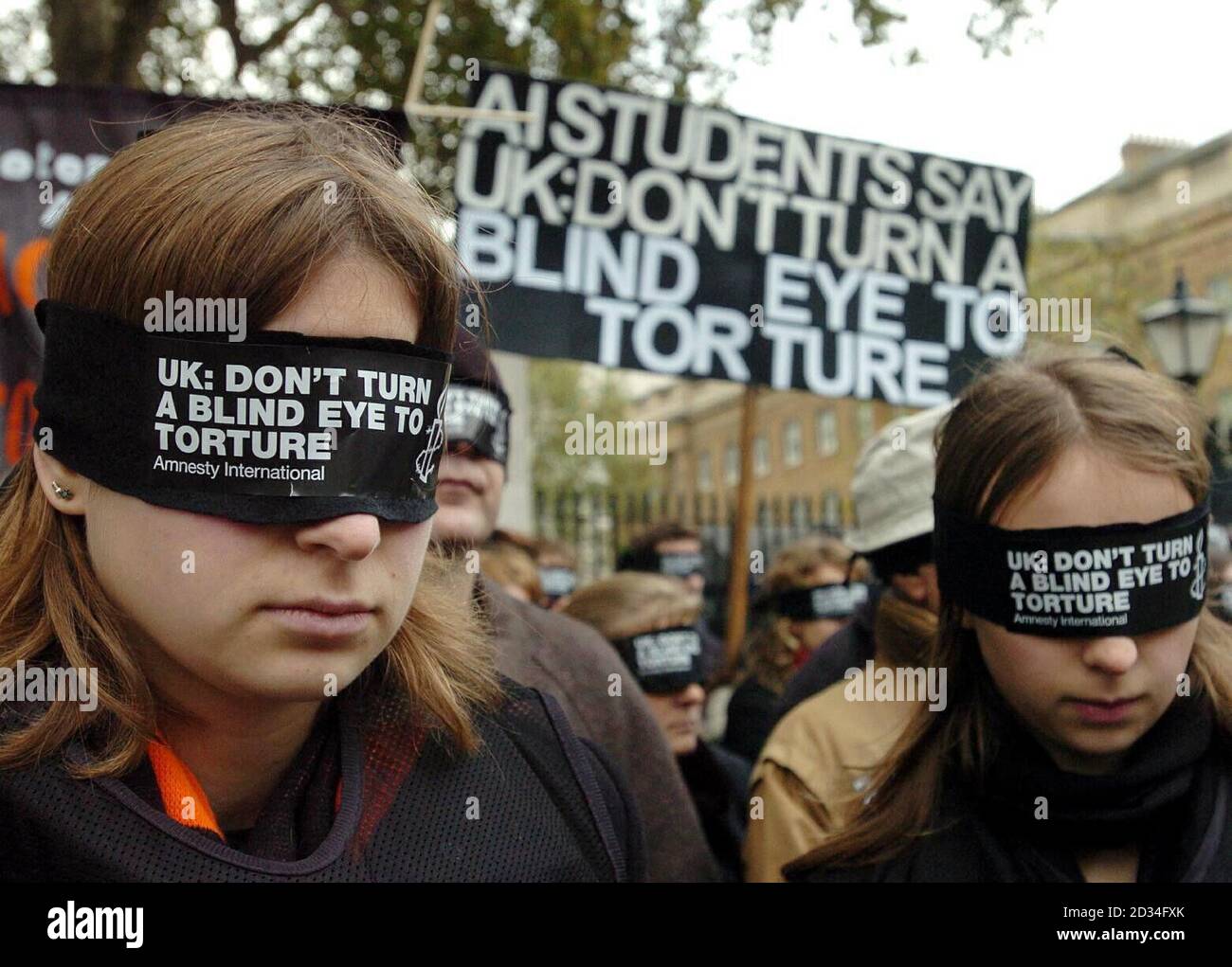 Blindfolded protesters at a demonstration organised by Amnesty International against the Government's deportation agreements with some foreign countries, outside Downing Street in central London, Sunday November 27, 2005. The protesters, wearing black blindfolds with the slogan: "Don't turn a blind eye to torture," chanted: "Stop torture," as they huddled together against the cold. See PA story PROTEST Torture. PRESS ASSOCIATION photo. Photo credit should read: Michael Stephens /PA. Stock Photo