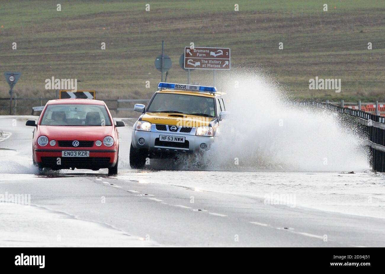 A coastguard vehicle turns in flood water at The Strood causeway in Essex as Mersea Island prepares for flooding at high tide and a possible evacuation of properties. Stock Photo