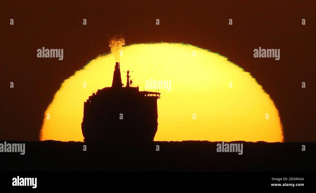 Retransmission adding byline of photographer Owen Humphreys. The DFDS King Seaways, travelling across the North Sea, is silhouetted by the rising sun as the 161m long cruise ferry arrives at Tynemouth. Stock Photo