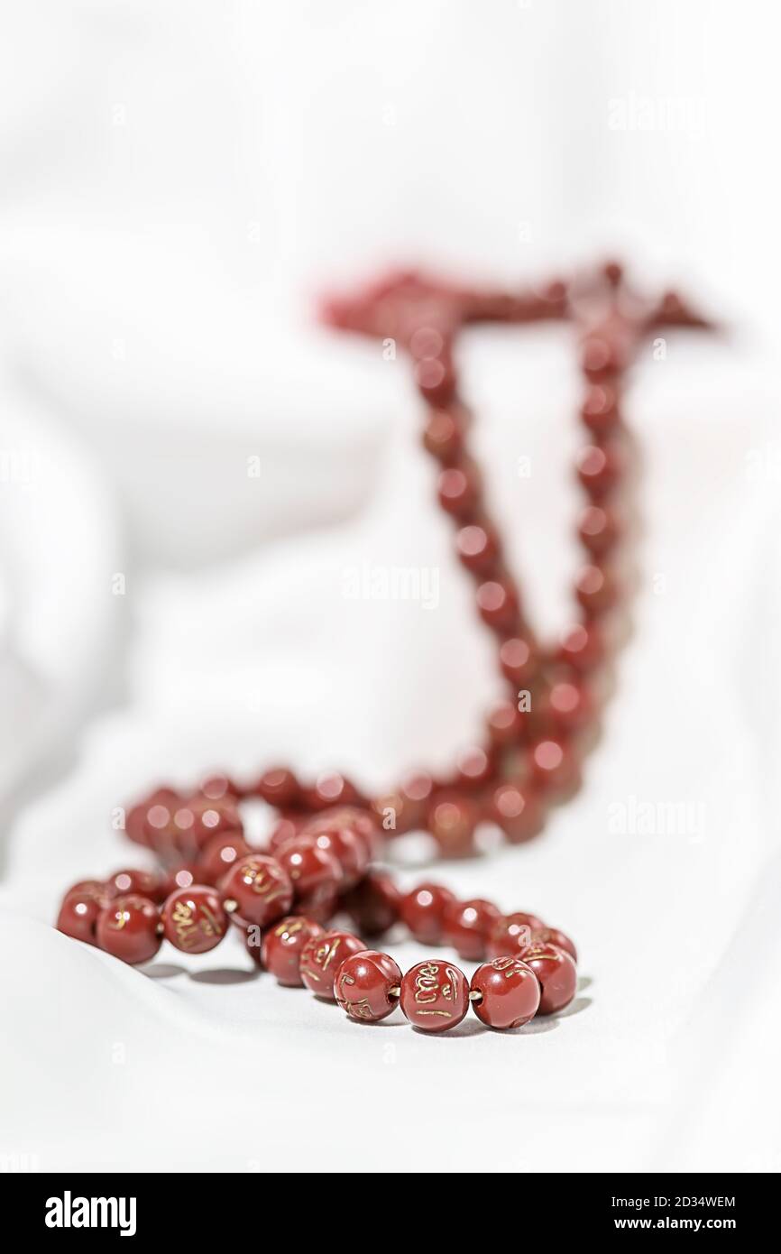Islamic prayer beads on a white silk fabric. Design concepts on the