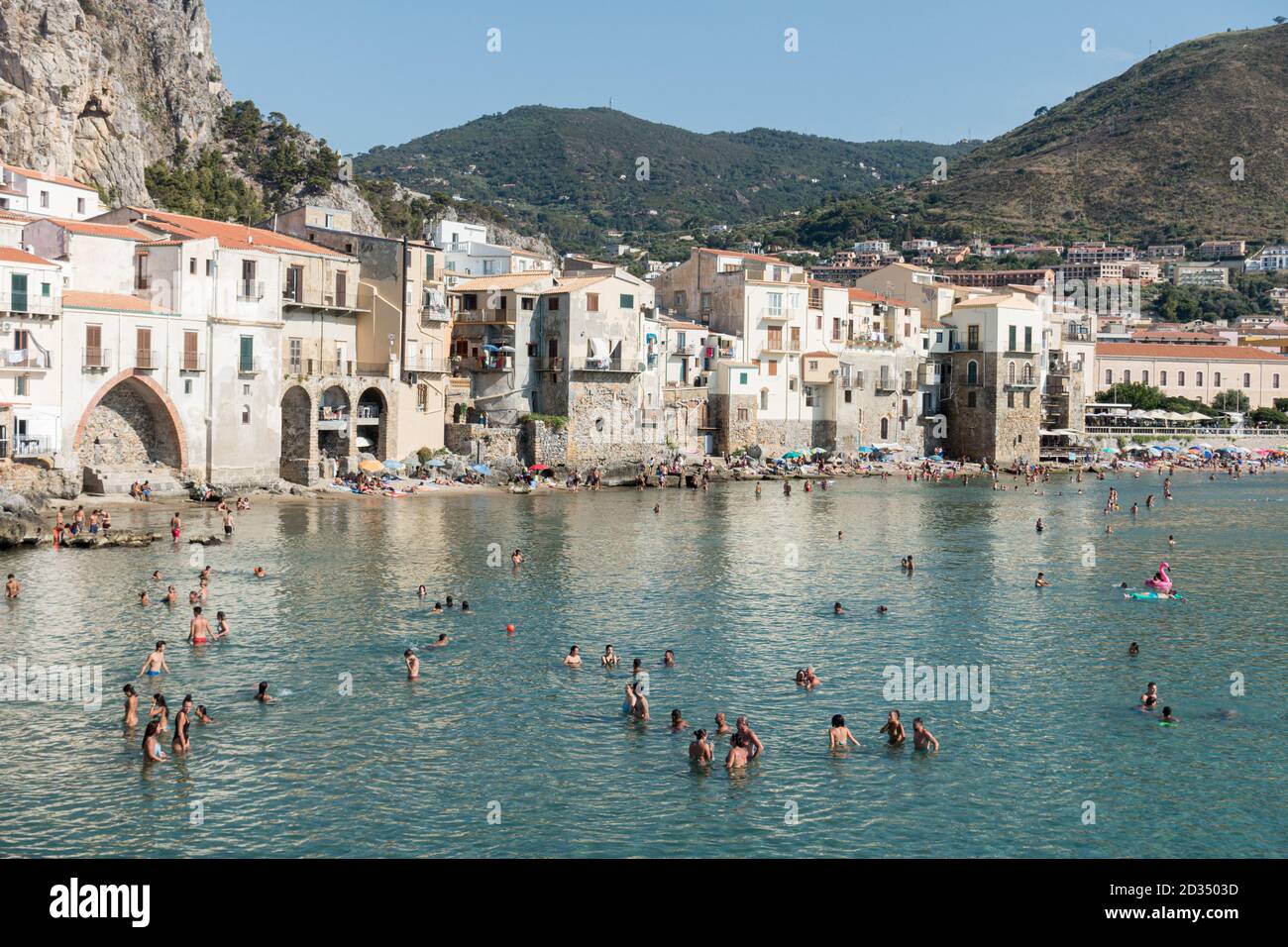 people swim in the sea at the bay of Cefalu, Sicily Stock Photo Alamy