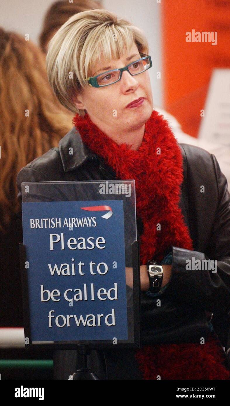 Passengers wait in line at a BA information desk at Edinburgh Airport