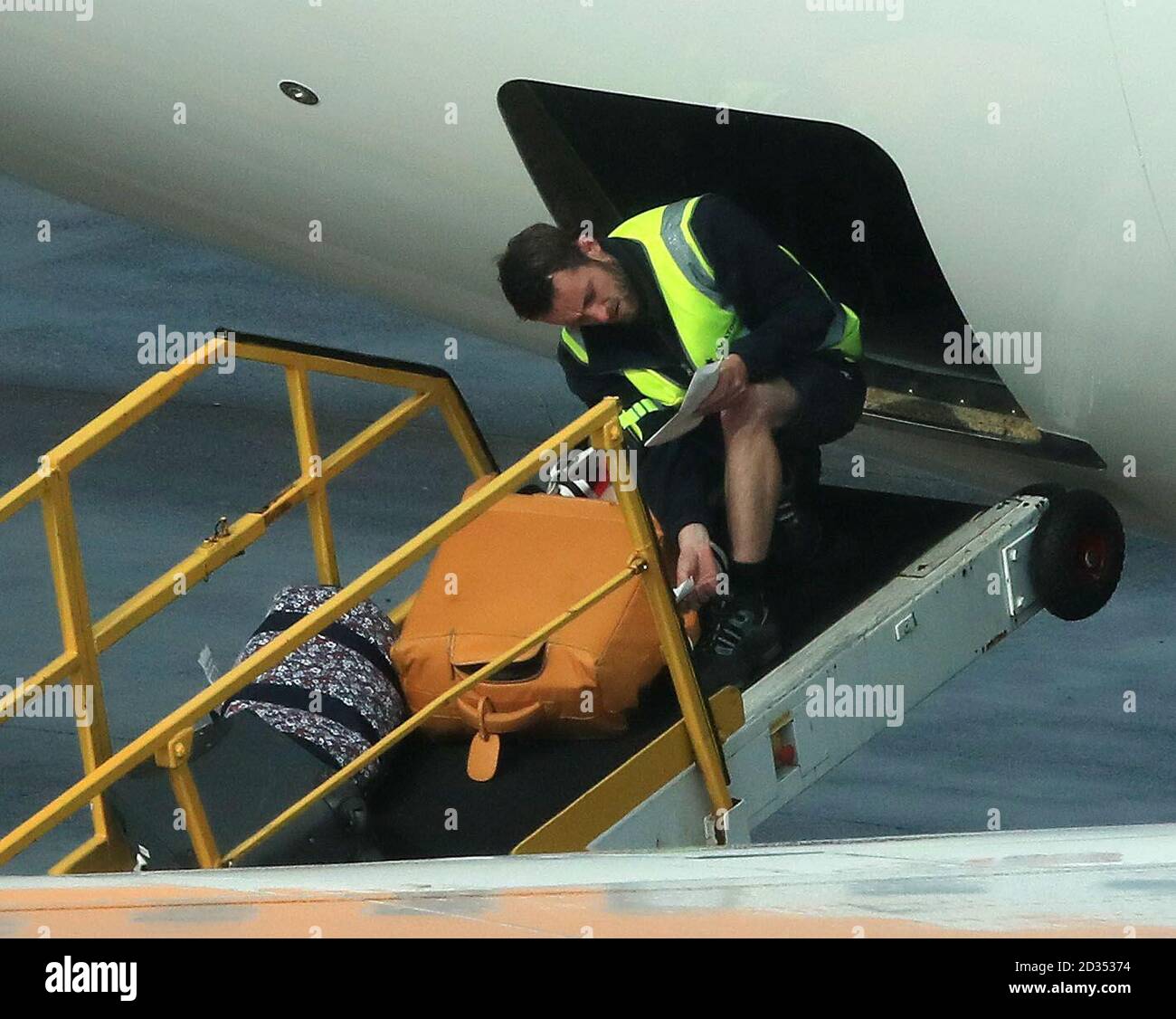 Baggage handlers on the runway at terminal one Manchester Airport Stock