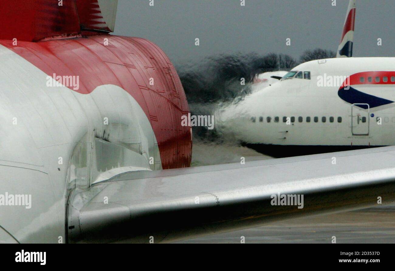 A view of adjacent aircraft is distorted by the heat from the engines of a British Airway's Boeing 747 after landing at Heathrow. Stock Photo