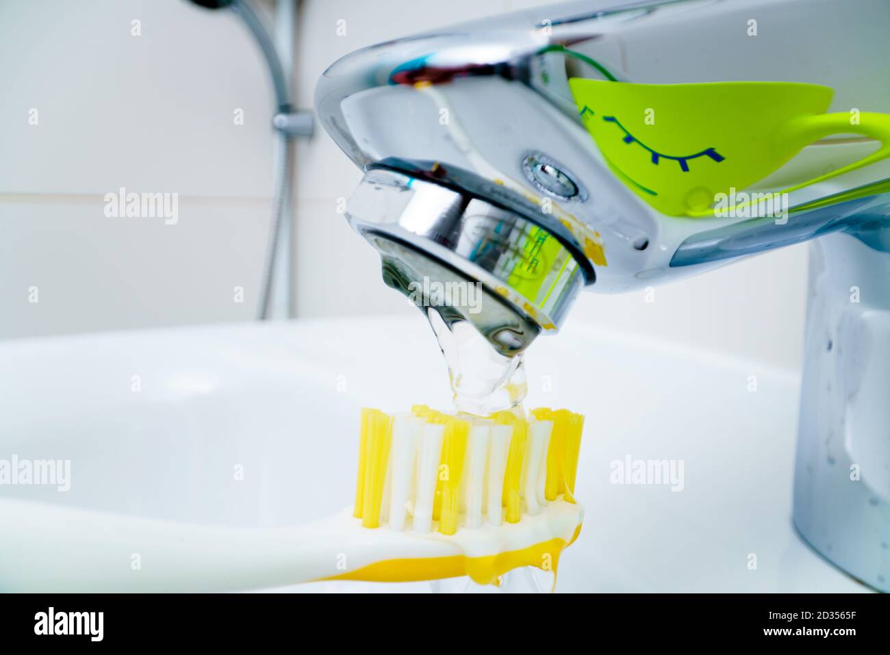 Bathroom sink and faucet with toothbrushes and soap dispenser Stock Photo -  Alamy