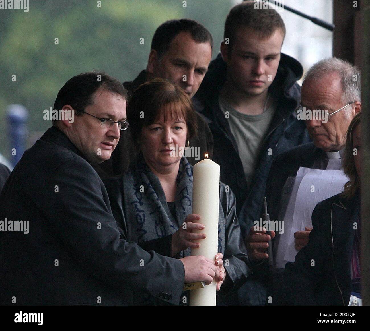 RETRANSMITTED WITH ADDITIONAL CAPTION INFORMATION  Melanie Jones the mother of murdered schoolboy Rhys Jones holds a candle with Father Andrew Unsworth as husband Stephen and son Owen looks on at a community Vigil in Croxteth Park, Liverpool. Stock Photo