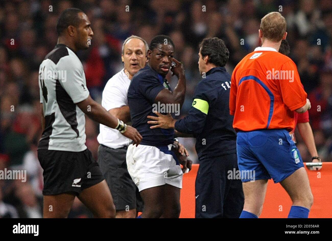 France's Serge Betsen (centre) is lead from the field after picking up and injury. Stock Photo
