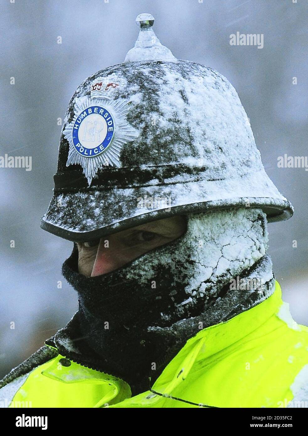 A police officer watches over the demonstration by workers outside the Lindsey Oil Plant at Killingholme in North Lincolnshire which continued today despite the arctic blizzards. Stock Photo