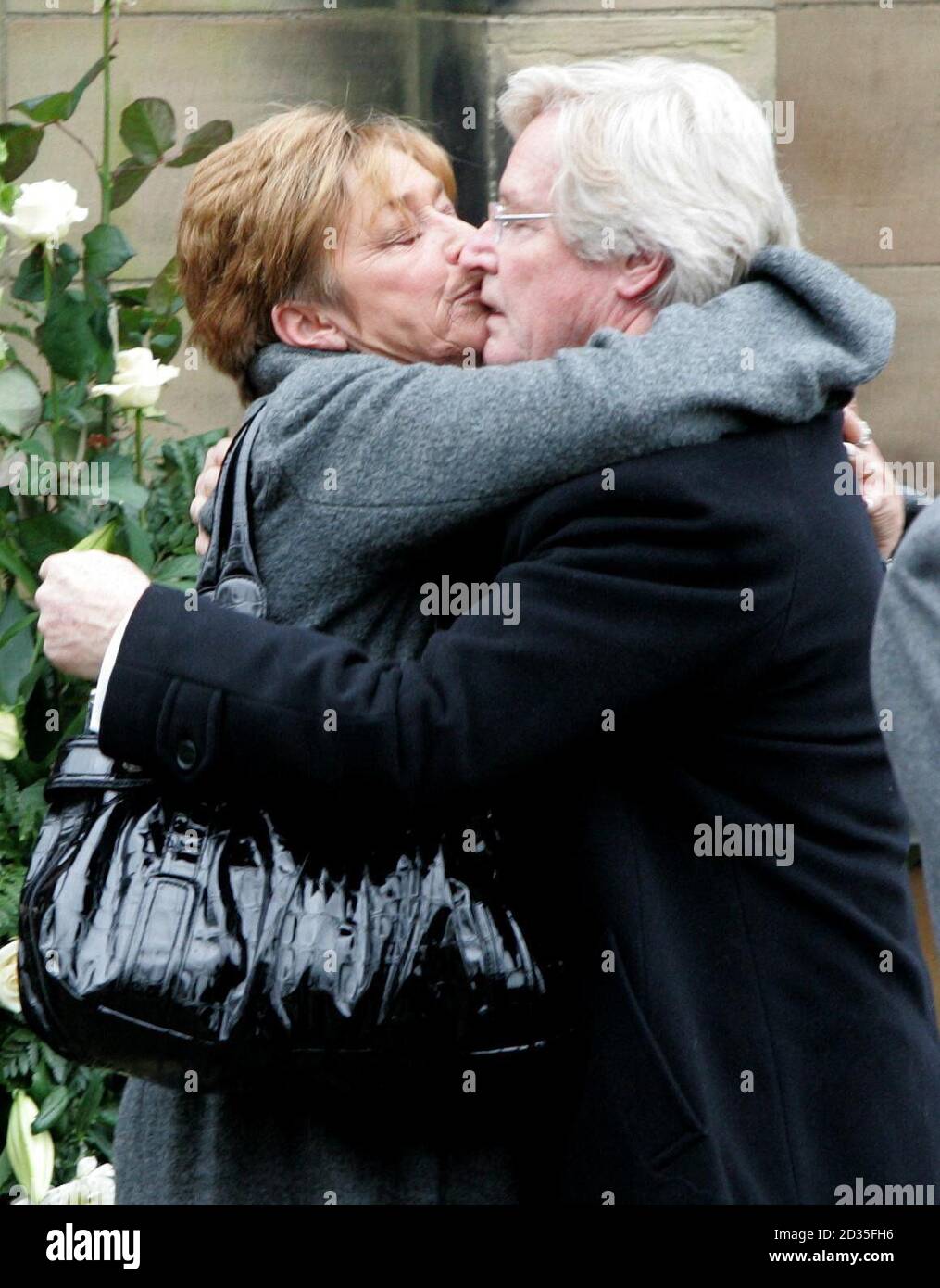 Coronation Street actress Anne Kirkbride kisses on screen husband Bill Roache after a memorial service for his wife Sara, at St Bartholomew's Church, Wilmslow, Cheshire. Stock Photo