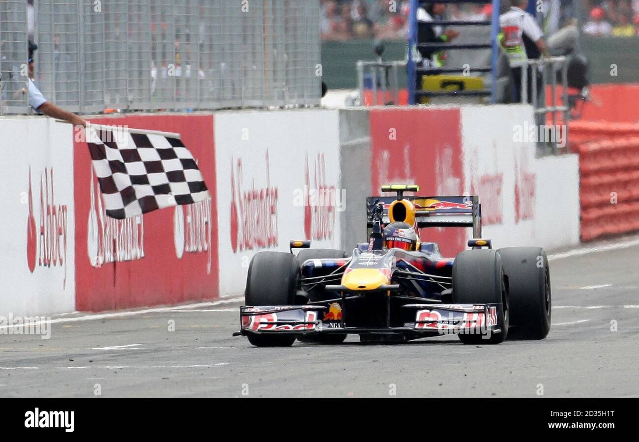 Red Bull's Sebastian Vettel of Germany celebrates his victory as he passes the chequered flag during the British Grand Prix at Silverstone, Northamptonshire. Stock Photo