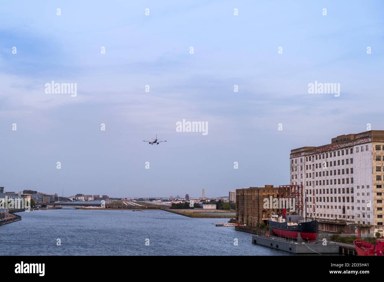 UK, London, Docklands. Aircraft arriving at City Airport, Abandoned Millennium Mills factory, Royal Victoria Dock, East End Stock Photo