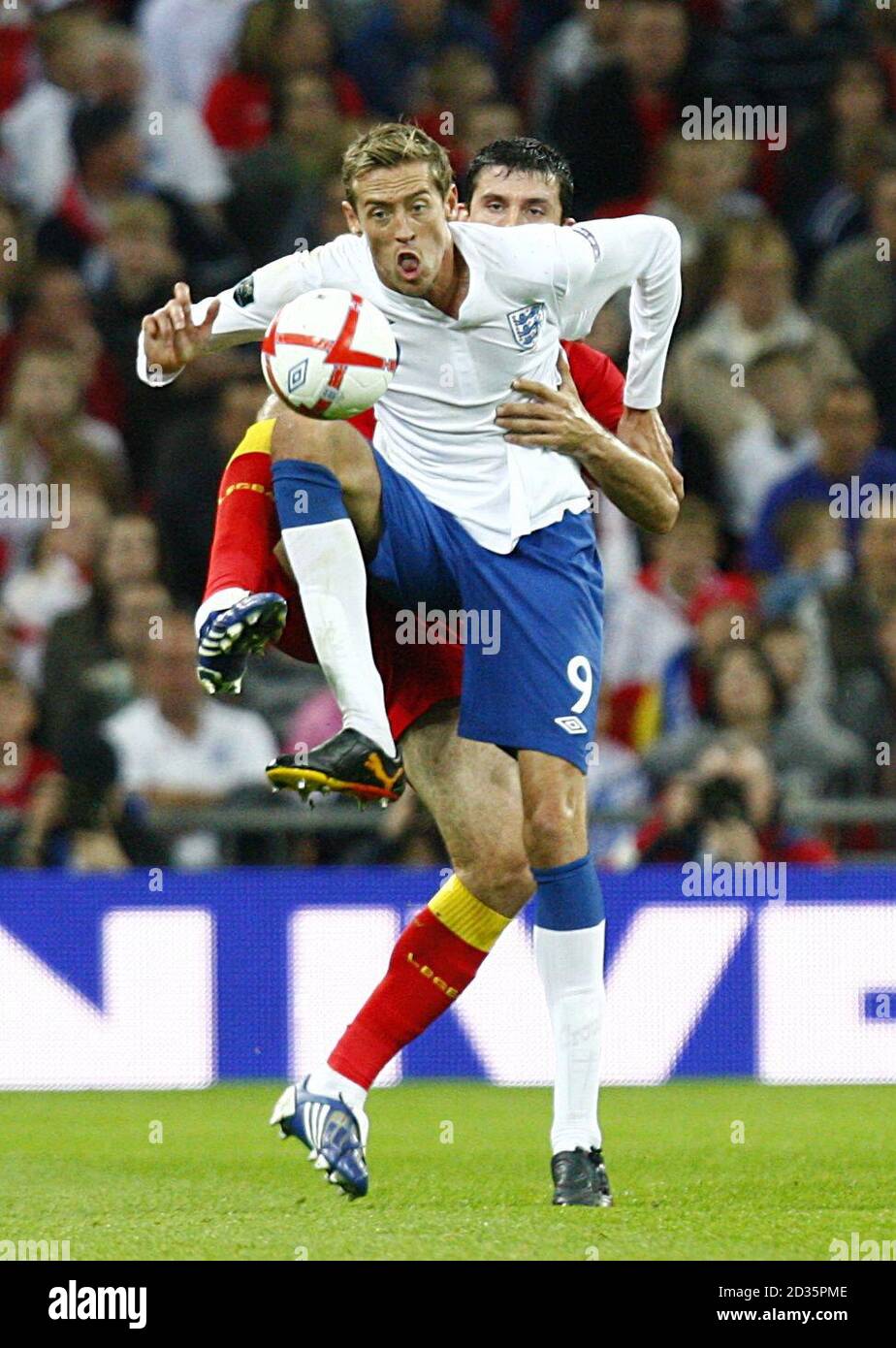 England's Peter Crouch is challenged by Montenegro's Miodrag Djudovic. Stock Photo