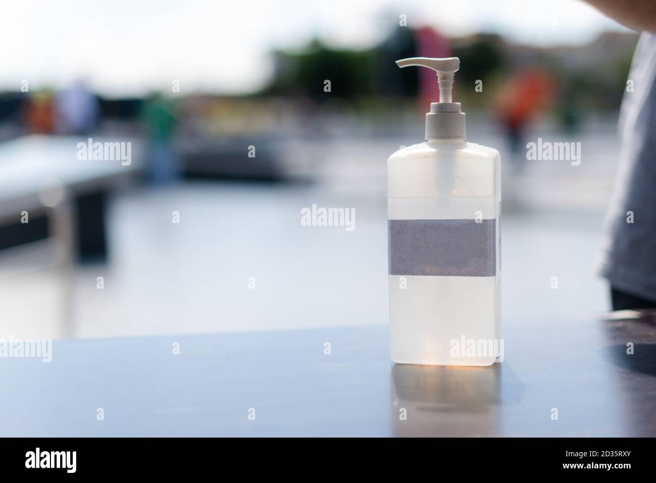 Hand sanitizer gel in public. Antibacterial lotion bottle outside. Close up view of antiseptic in the street. Stock Photo
