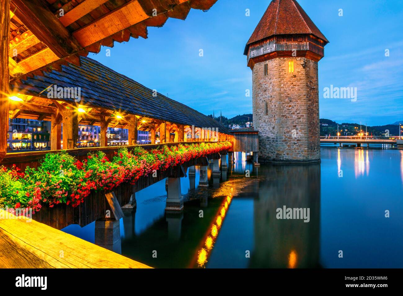 Amazing nightlife of Lucerne illuminated at night on Lake Lucerne, Switzerland. Water Tower from historic covered wooden footbridge Chapel Bridge over Stock Photo
