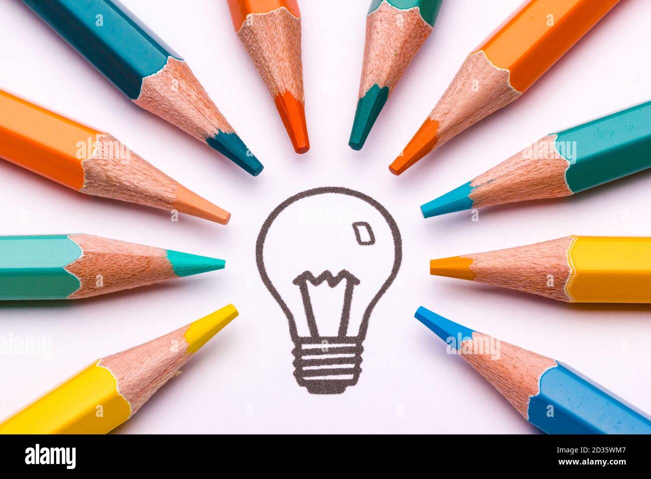 A light bulb surrounded by colour pencils as a symbol of creativity and art Stock Photo