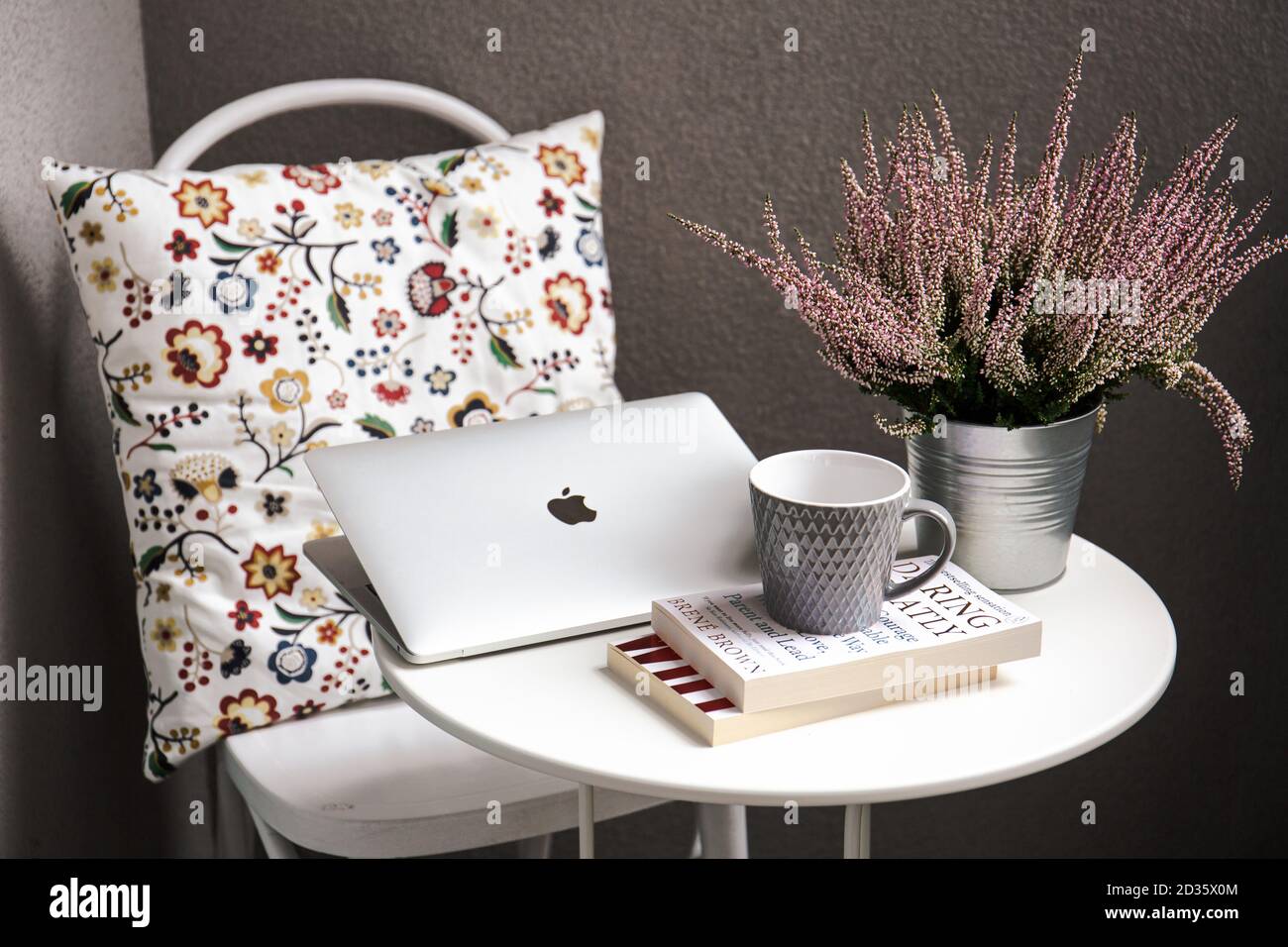 ORADEA, ROMANIA - Sep 20, 2017: A Macbook sat on a table next to a cup of  coffee, a stack of books and a flower pot Stock Photo - Alamy