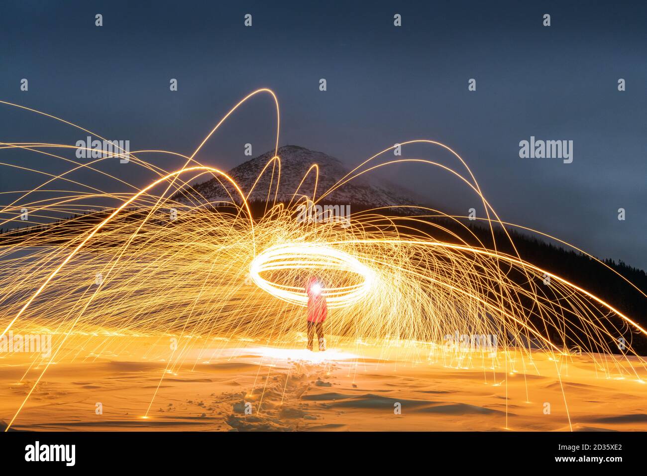 Fire show with lot of sparks in night winter mountains. Landscape photography Stock Photo