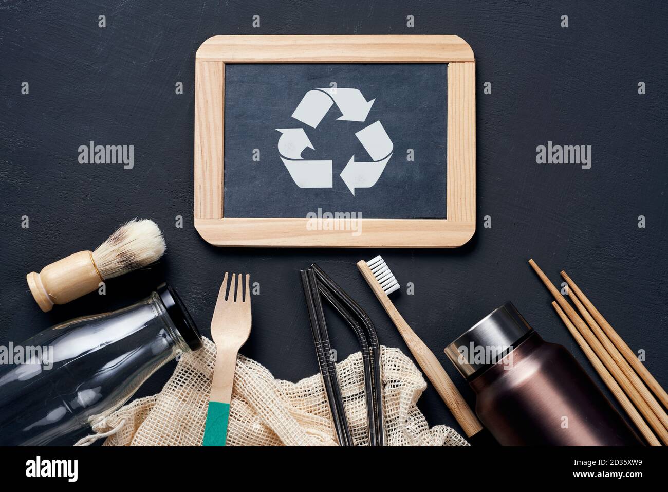 a pile of no-plastic sustainable household items, such as refillable metal and glass bottles, shopping mesh bags, or wooden toiletries, cutlery and ch Stock Photo