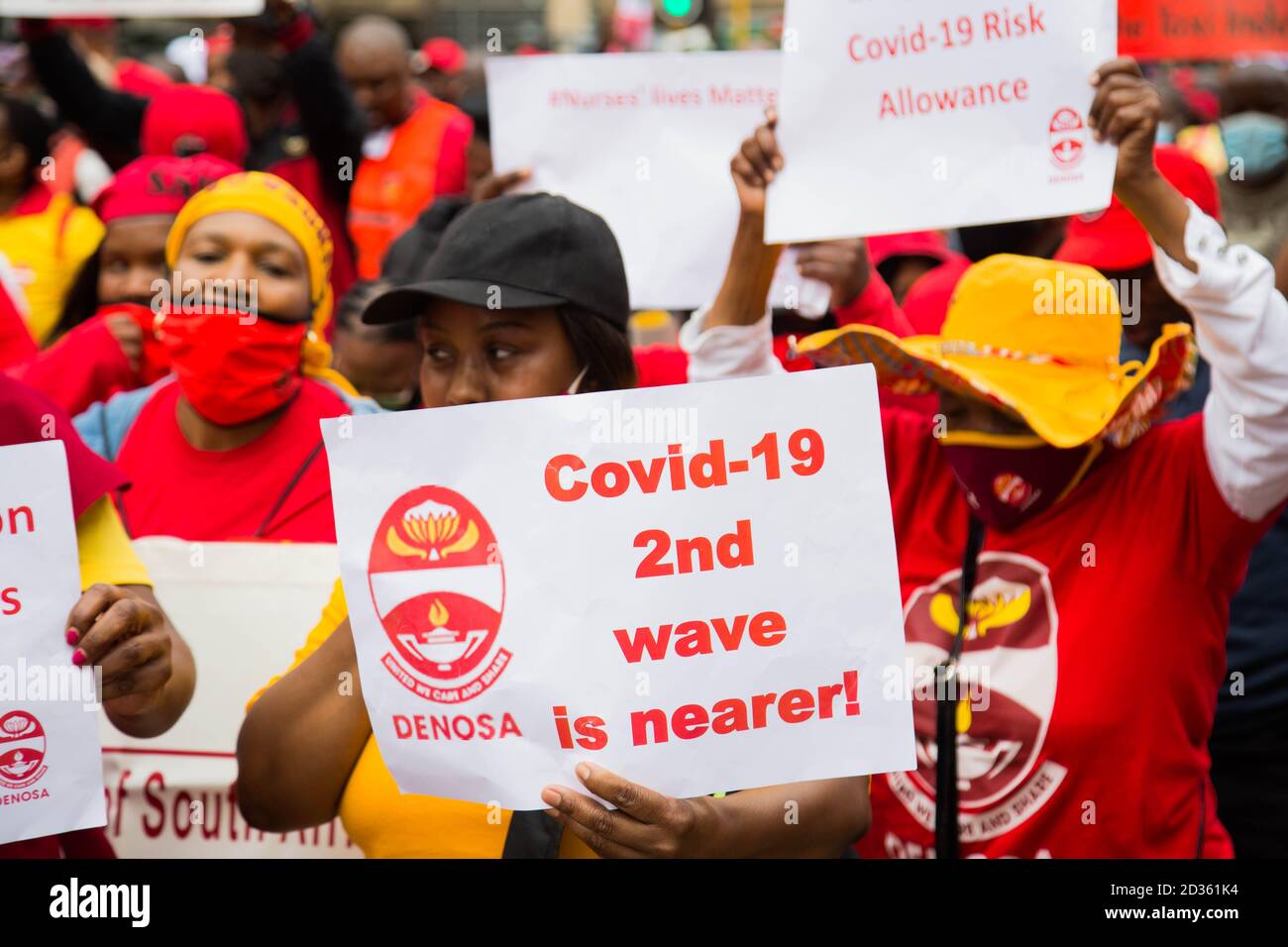 A member of  the Congress of South African Trade Unions displays a placard reading ' Covid-19 2nd wave is nearer' during the strike.Congress of South African Trade Unions took to the streets of Pretoria in a strike against government with the encouragement of the Federation of Trade Unions to challenge the rigged economic system in South Africa. Stock Photo