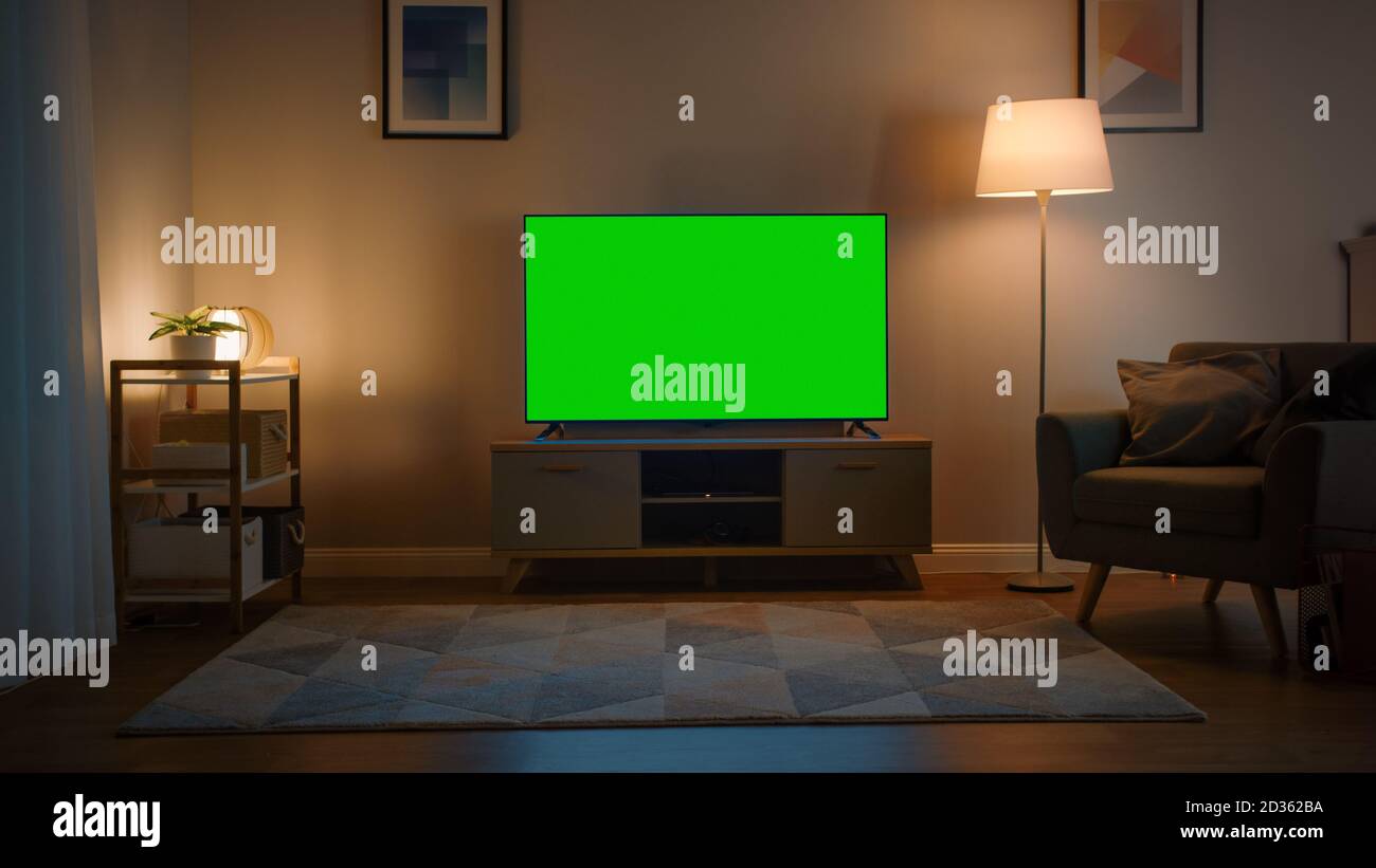 Shot of a TV with Horizontal Green Screen Mock Up. Cozy Evening Living