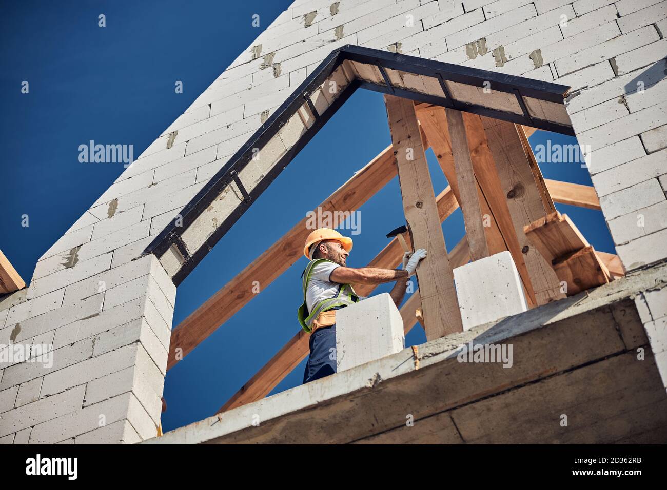 Professional builder using a hammer to construct a house Stock Photo
