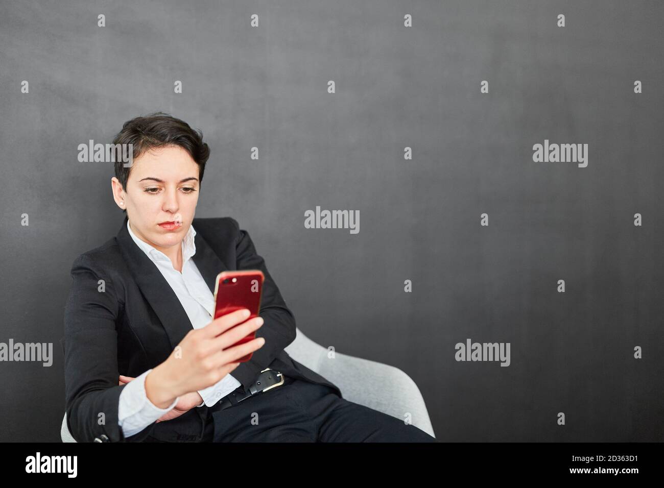 Young businesswoman reading a text message as a message or warning on the smartphone Stock Photo