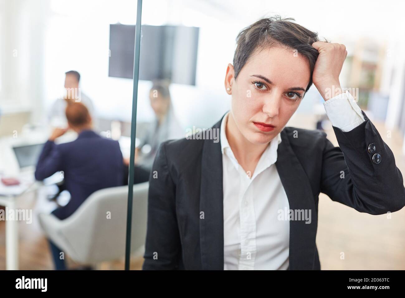 Young business woman with headache due to overtime and overload Stock Photo