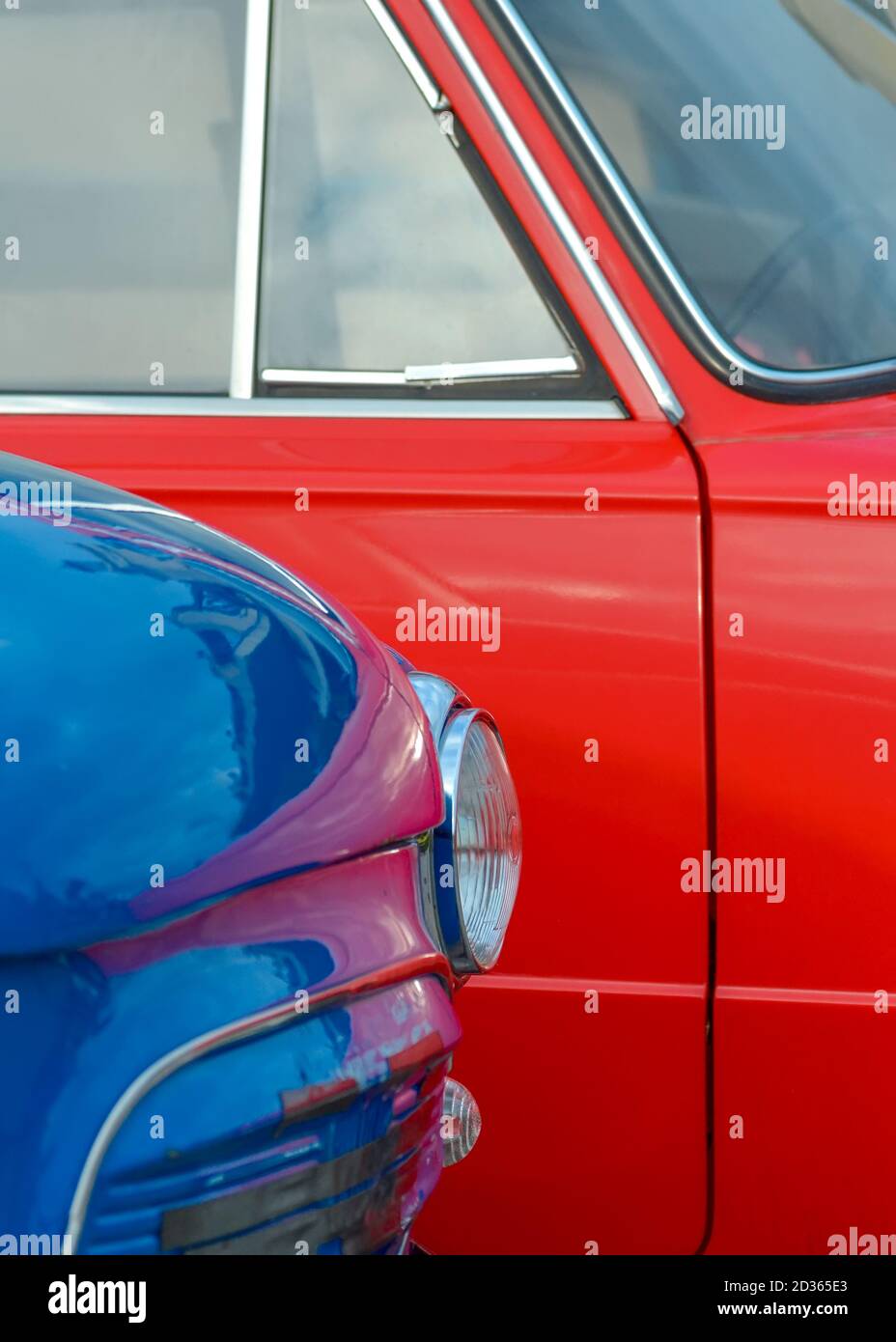 Headlight of a blue vintage car on the background of a red car close-up Stock Photo