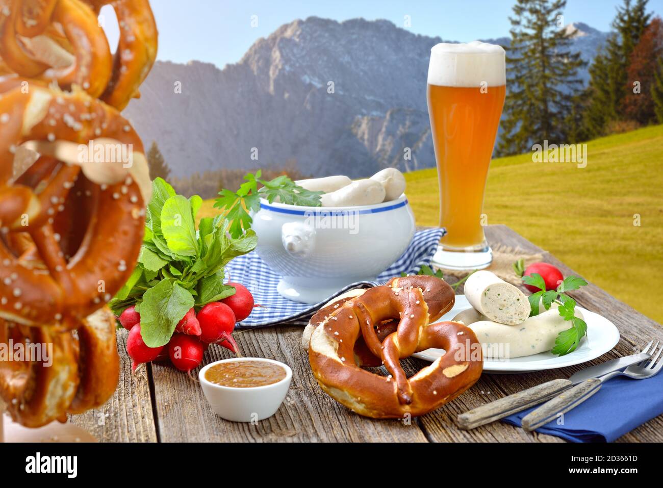 Hearty breakfast with veal sausages, fresh pretzels and a wheat beer outside in the Bavarian mountains near Garmisch-Partenkirchen Stock Photo