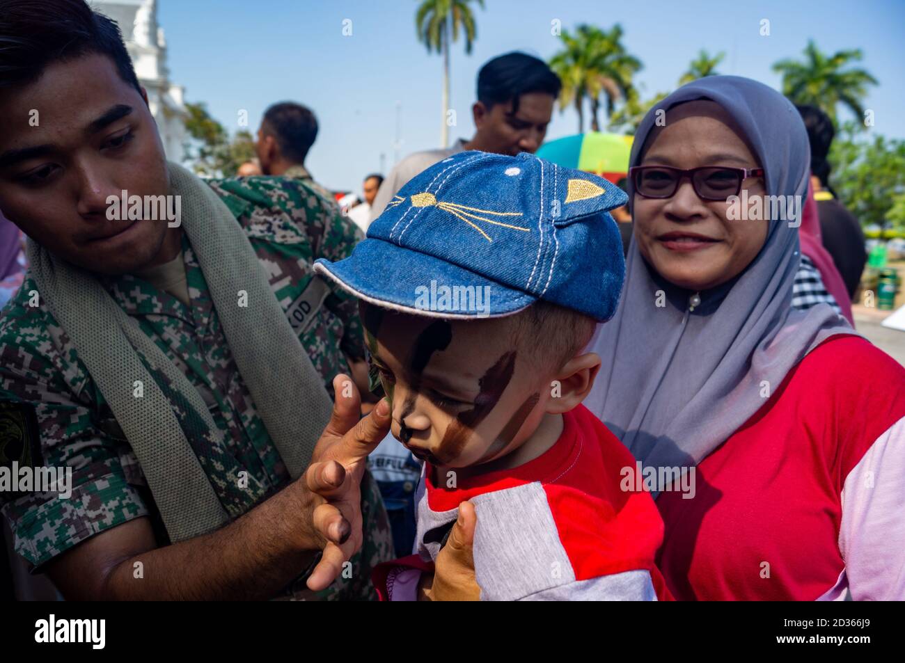 Georgetown, Penang/Malaysia - Feb 29 2020: Unidentified kid get camouflage make-up face paint by Malaysia soldier Stock Photo
