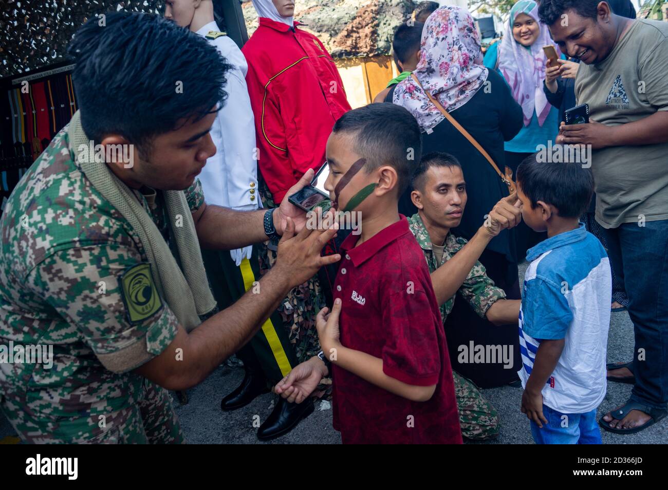 Georgetown, Penang/Malaysia - Feb 29 2020: Soldier help child make up camouflage during Malaysia army day at Padang Kota Lama. Stock Photo