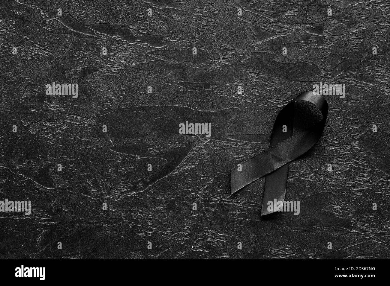 Black awareness ribbon on dark background. Mourning symbol Stock Photo