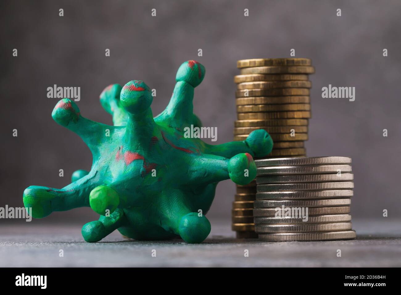 Toy coronavirus and various coins. Concept on the impact of coronavirus on business around the world Stock Photo