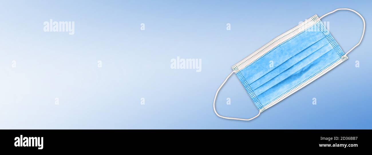blue face mask or surgical mask on wide colored background with copy space Stock Photo