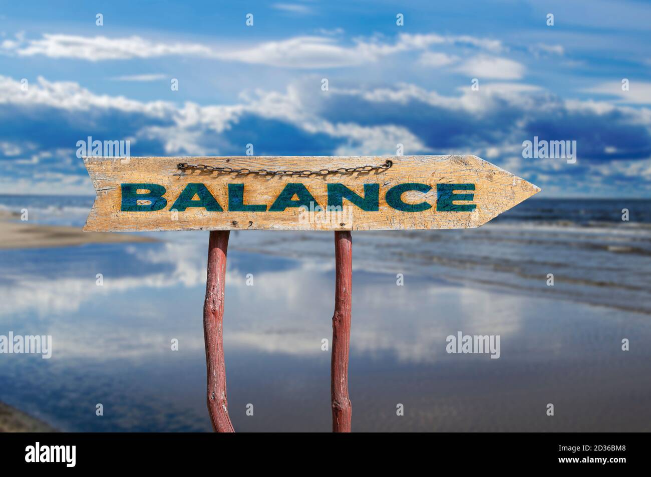 Balance wooden arrow road sign against beautiful marine landscape. Baltic sea during sunny day with beautiful clouds with gulls in the waves in Jurmal Stock Photo